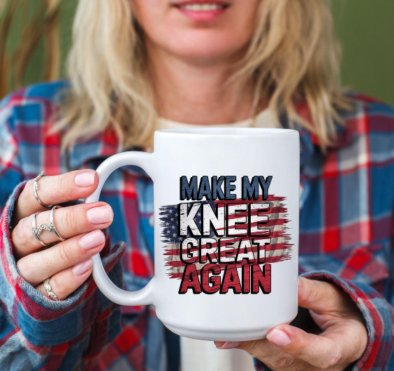 White ceramic mug held by a woman in plaid shirt, featuring the phrase 'Make My Knee Great Again' over a distressed American flag – hilarious gift for old farts, aging adults, knee surgery survivors, physical therapy warriors, and patriotic seniors with a funny bone.