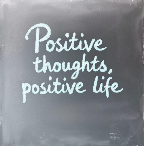 Chalkboard-style image with light blue handwritten text that reads: “Positive thoughts, positive life, life.” A motivational quote emphasizing the connection between mindset and quality of life.